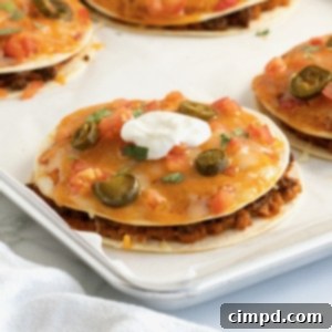 Pizzas made from tortillas with melted cheese, sliced jalapeño, and topped with sour cream.