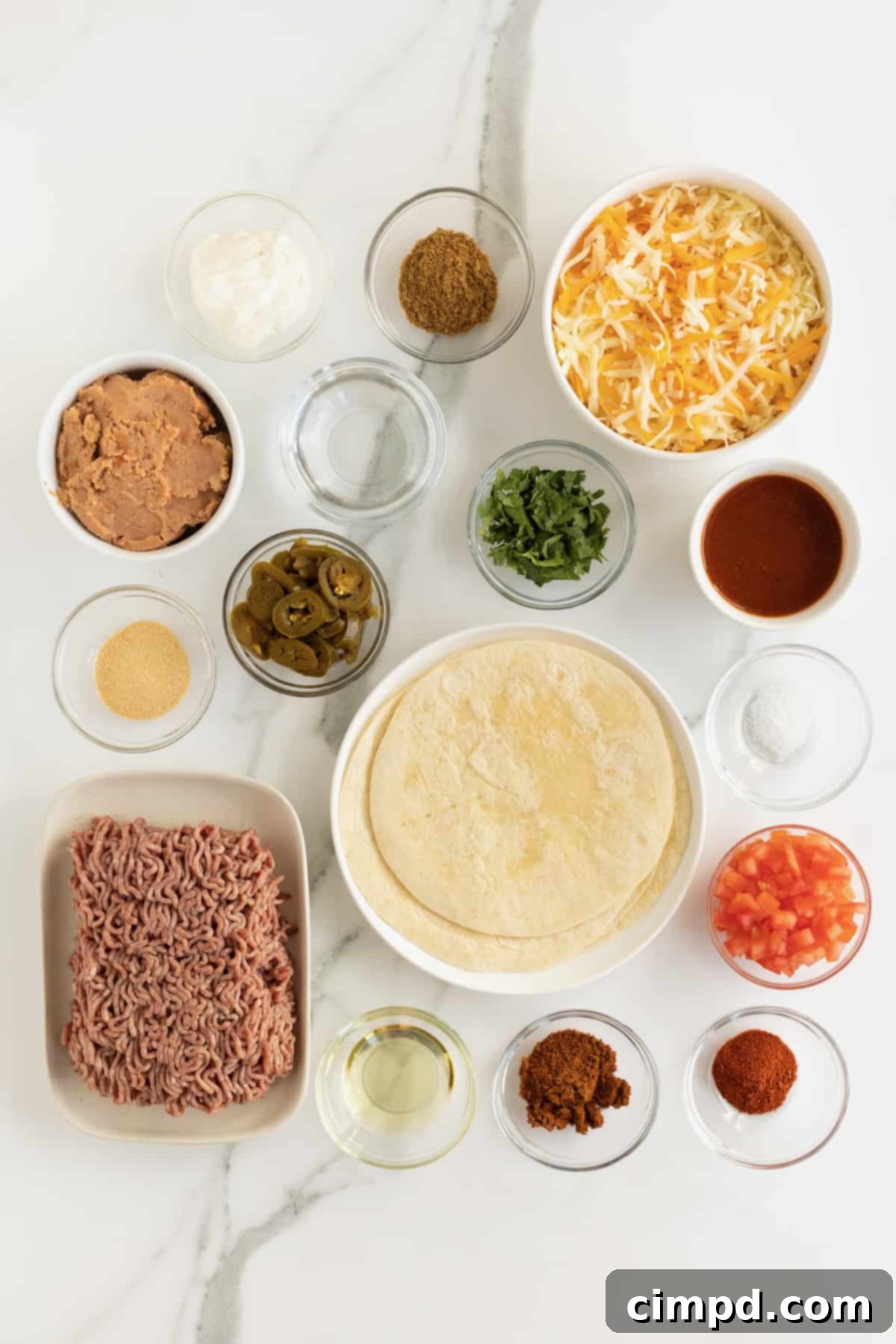 Canola oil, ground beef, chili powder, garlic powder, ground cumin, paprika, kosher salt, water, flour tortillas, refried beans, shredded Monterrey jack and cheddar cheese blend, enchilada sauce, diced fresh tomato, sliced jalapeño peppers, chopped fresh cilantro, sour cream in small glass containers.
