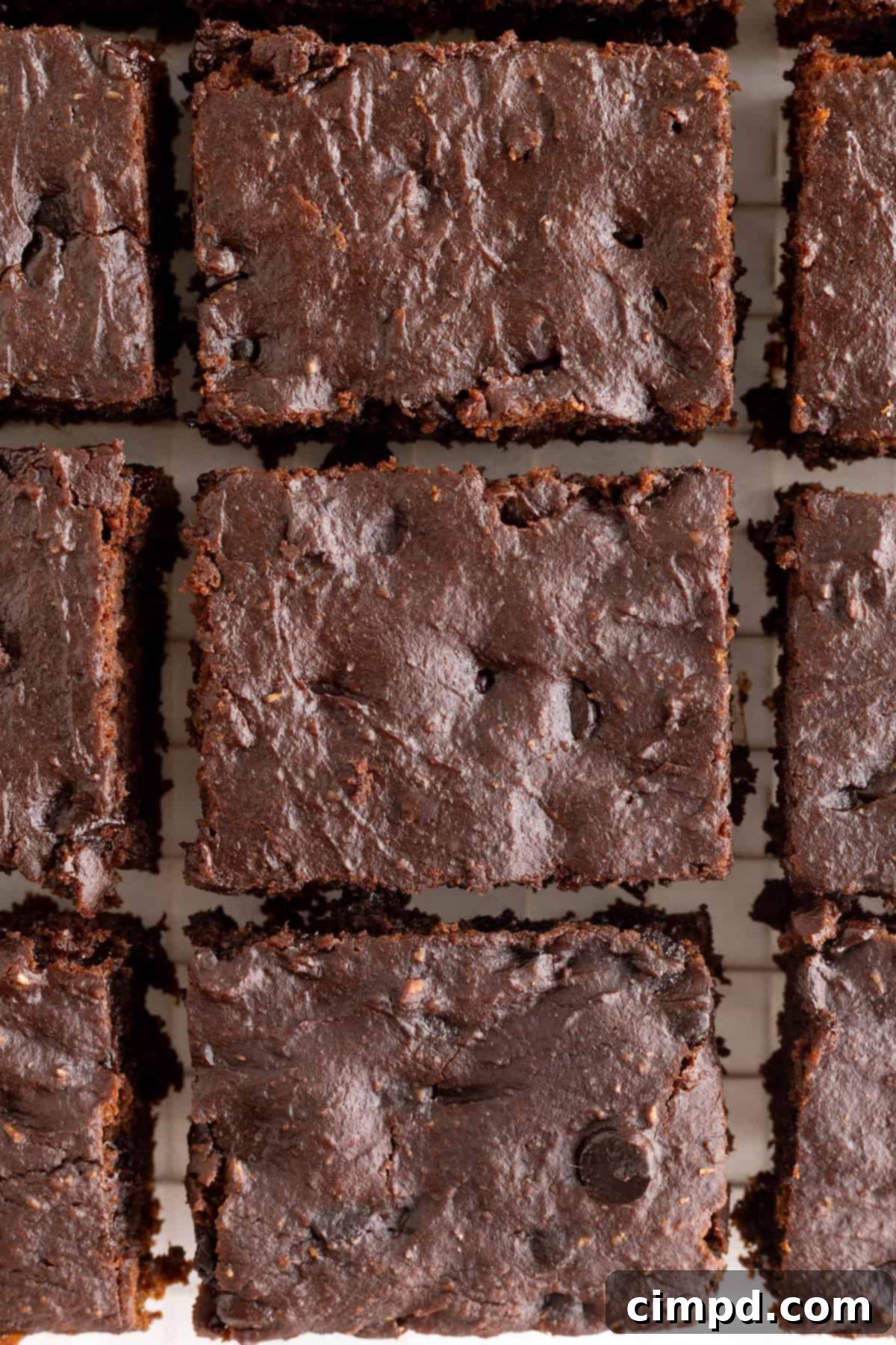 A glass baking dish filled with perfectly sliced whole wheat pumpkin brownies, showcasing their even cuts and moist texture.