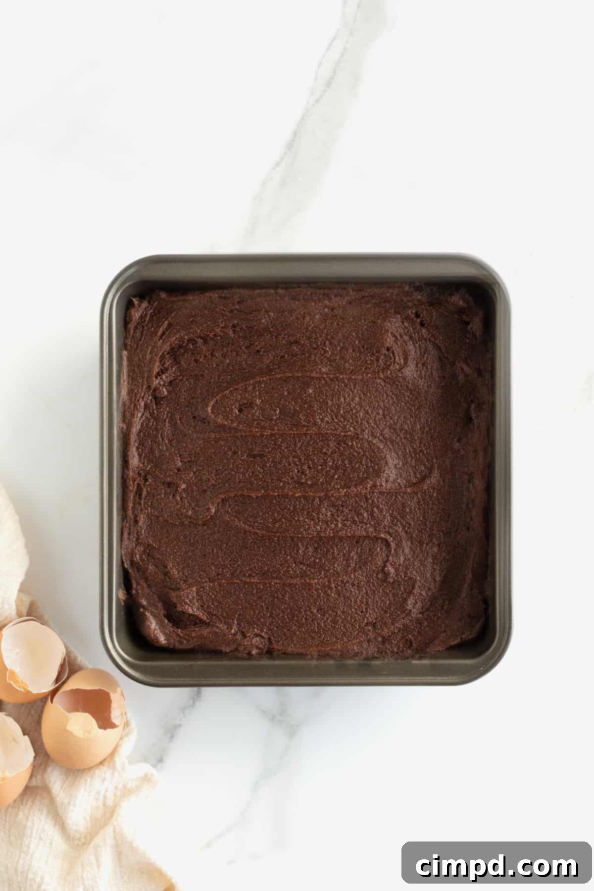 Nutella Brownie batter spread in a 9x9 square pan.