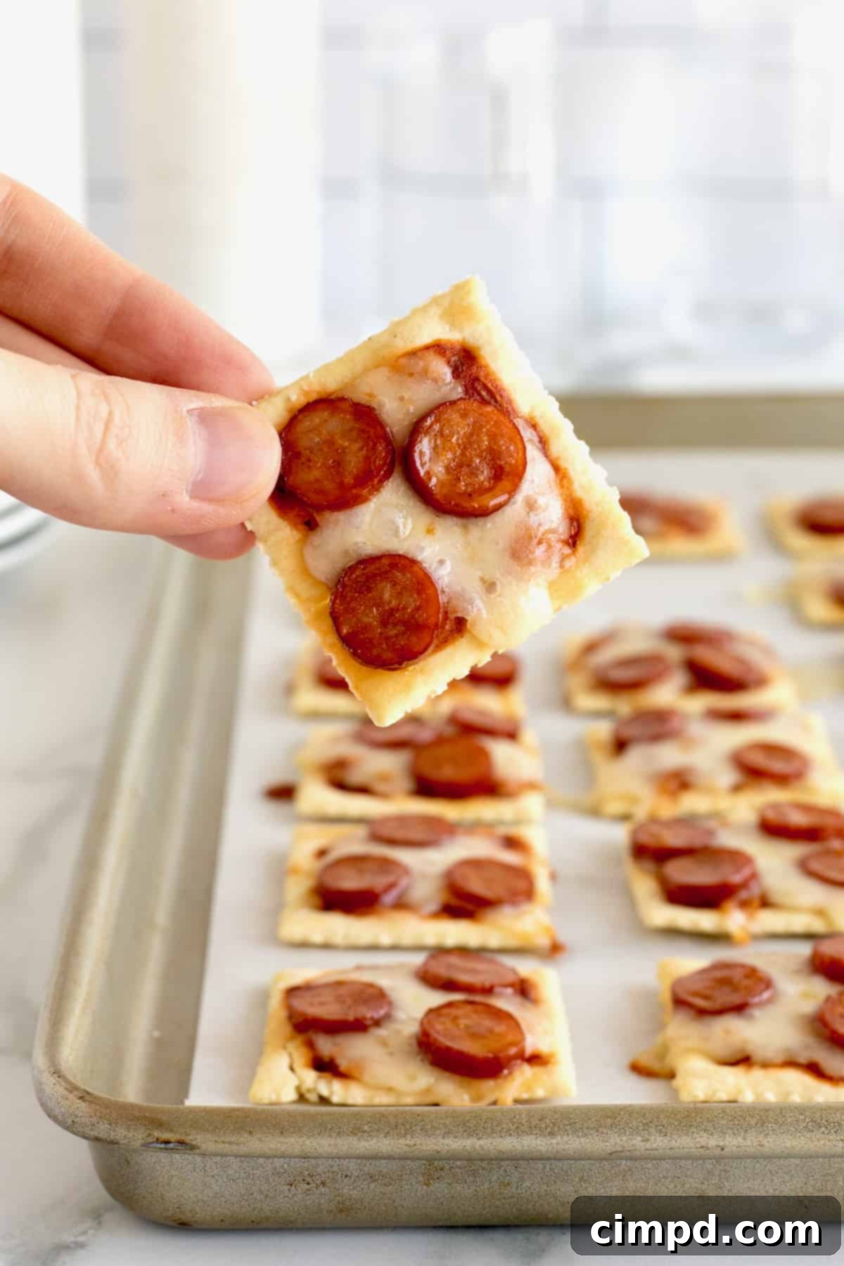 Crispy Pizza Bites 3 Close-up of baked pizza bites on saltine crackers, featuring perfectly melted mozzarella and crispy mini pepperoni.