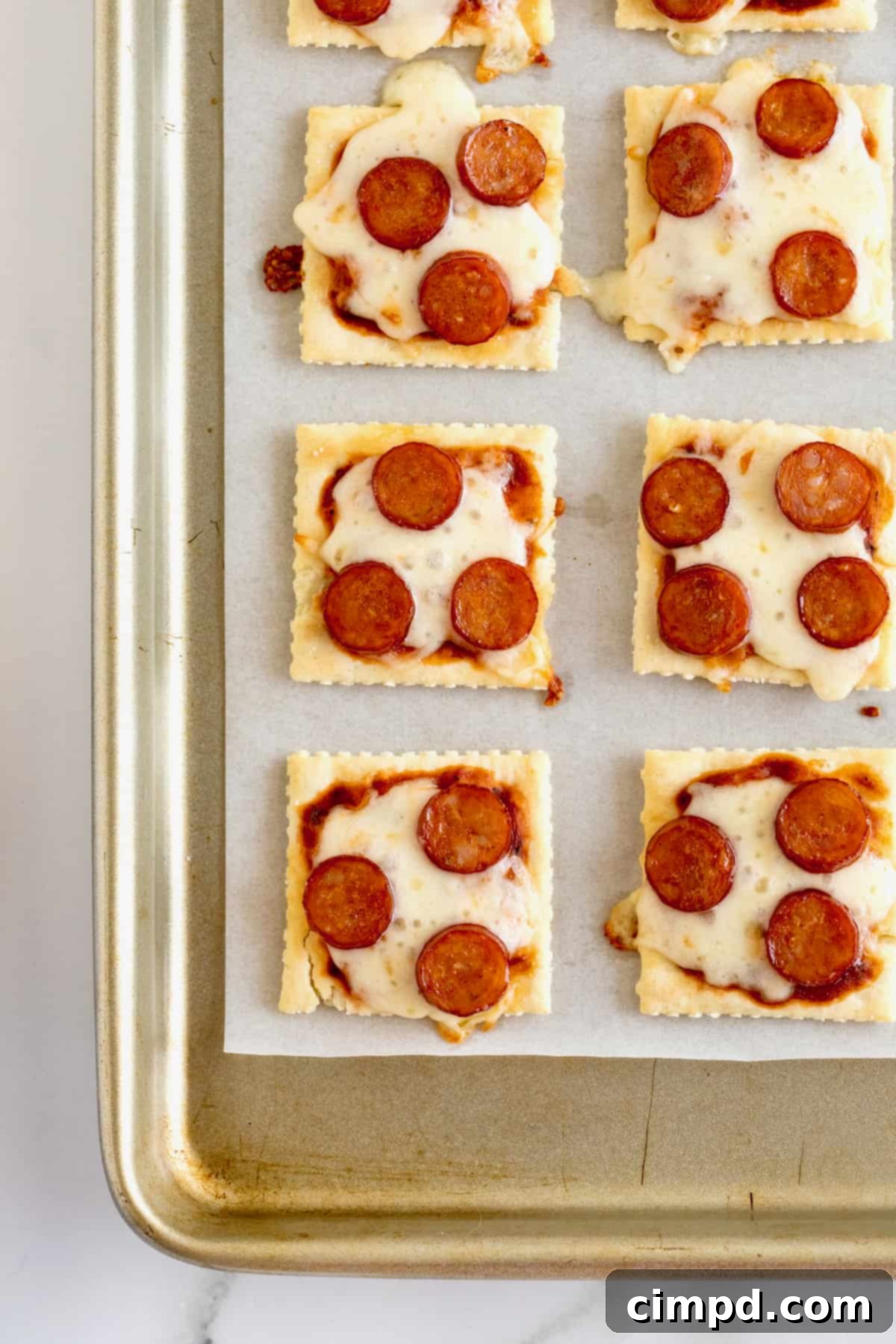 Crispy Pizza Bites 8 A plate of freshly baked pizza cracker bites made with saltine crackers, melted mozzarella, and mini pepperoni, ready to be eaten.