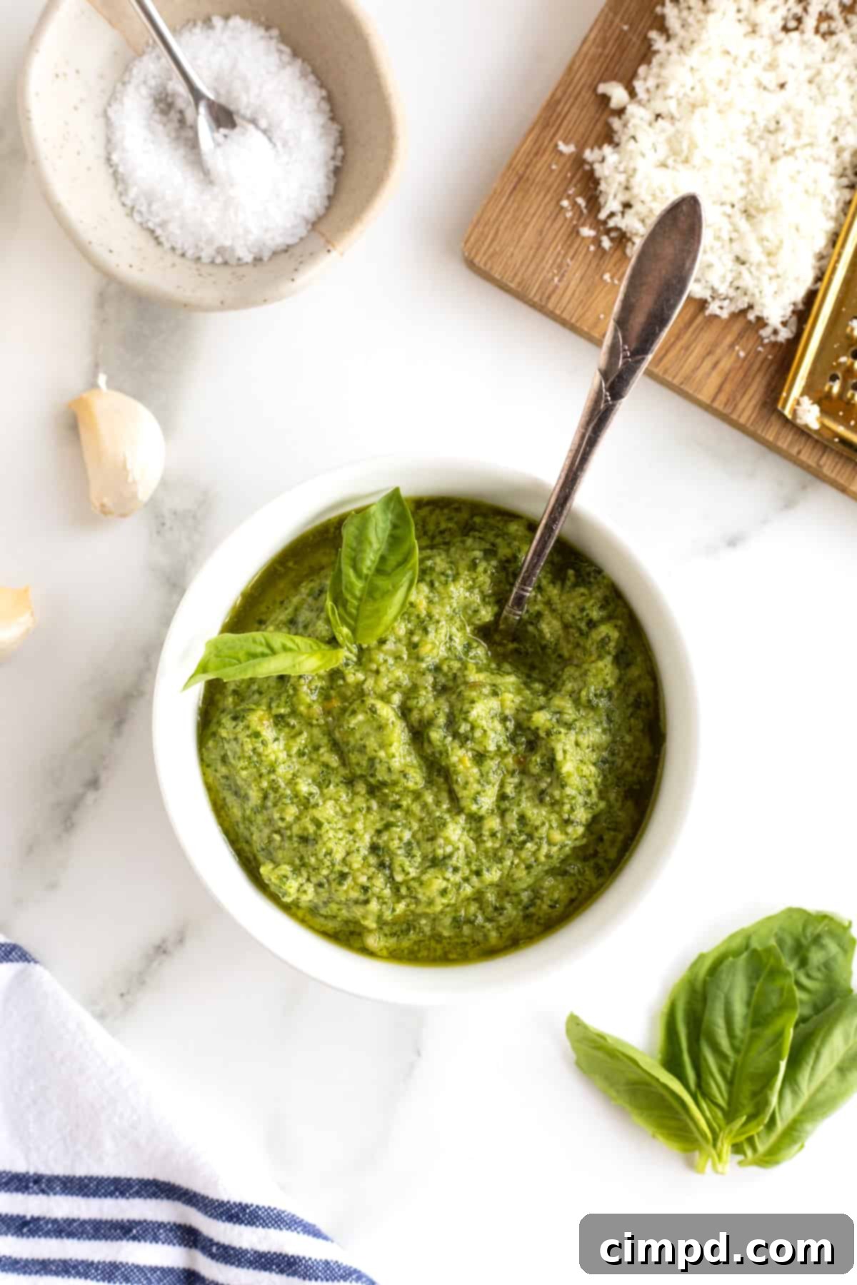 Crafting Your Own Fresh Basil Pesto 2 A white ceramic dish filled with vibrant green pesto, invitingly presented.