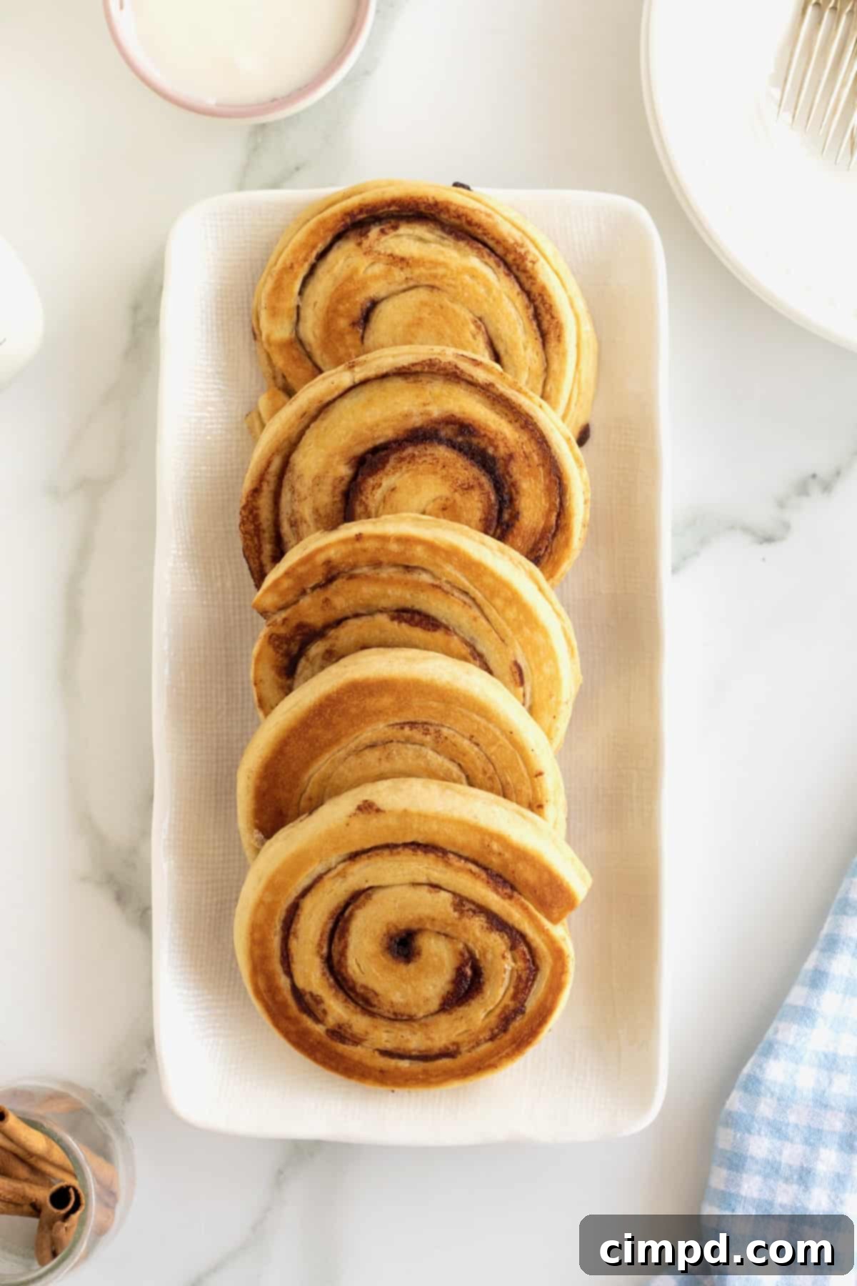 Cinnamon Swirl Pancakes 9 Five cinnamon roll pancakes on a rectangular white serving tray.