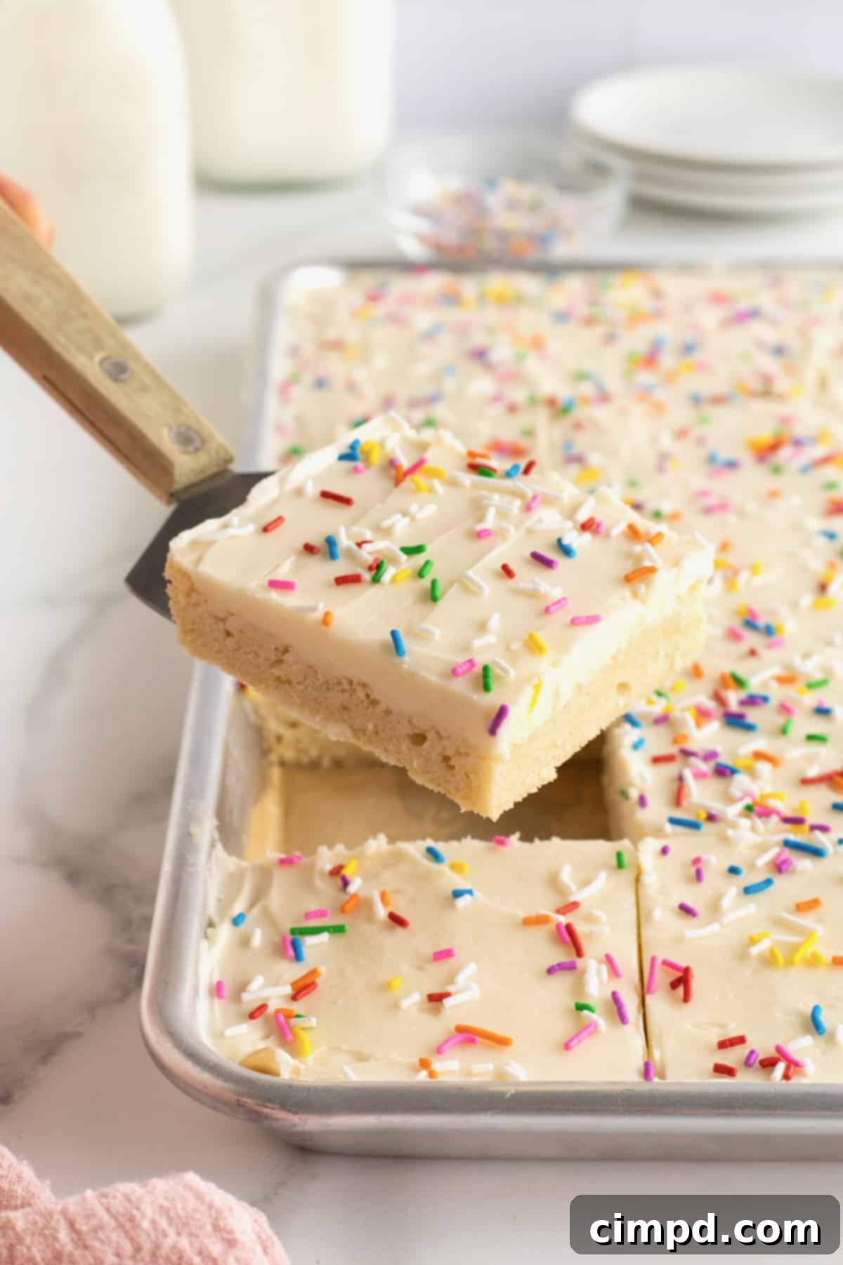 Soft Frosted Sugar Cookie Bars 4 A frosted sugar cookie bar on a spatula.