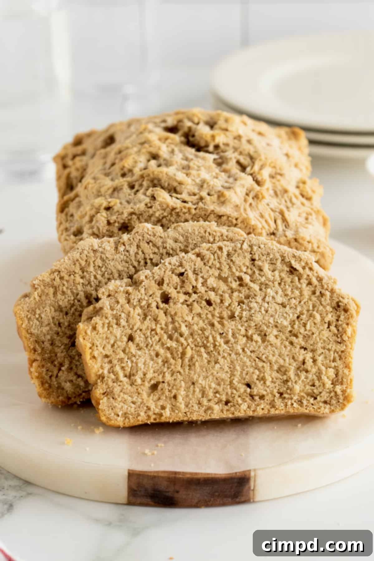 Pub-Style Beer Bread 6 A darker beer bread, made with a stout or porter, cut into slices on a round wooden cutting board.
