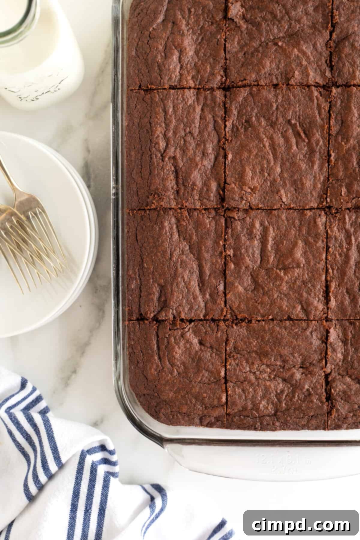 A glass baking dish filled with a batch of One Bowl Fudge Brownies, neatly cut into perfect one-inch squares.