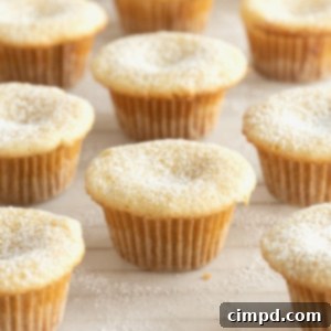 Chewy Butter Cake Squares 12 Nine delicious two-bite butter cakes are neatly arranged on a sheet of parchment, highlighting their golden tops and perfect size for a sweet treat.