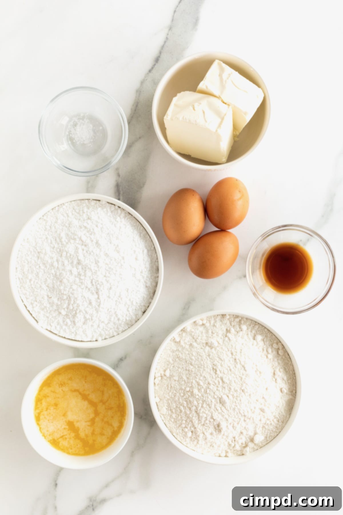 Chewy Butter Cake Squares 5 A vibrant flat lay shot displaying all the fresh and packaged ingredients required to make gooey butter cake, neatly arranged on a white surface, ready for baking.