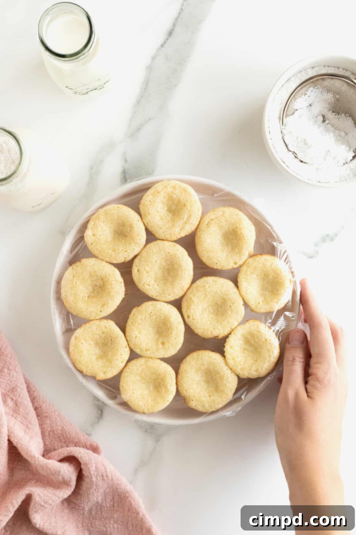 Chewy Butter Cake Squares 8 A white serving plate featuring twelve mini gooey butter cakes, beautifully arranged and ready to be served, showcasing their golden tops and perfect bite-sized form.