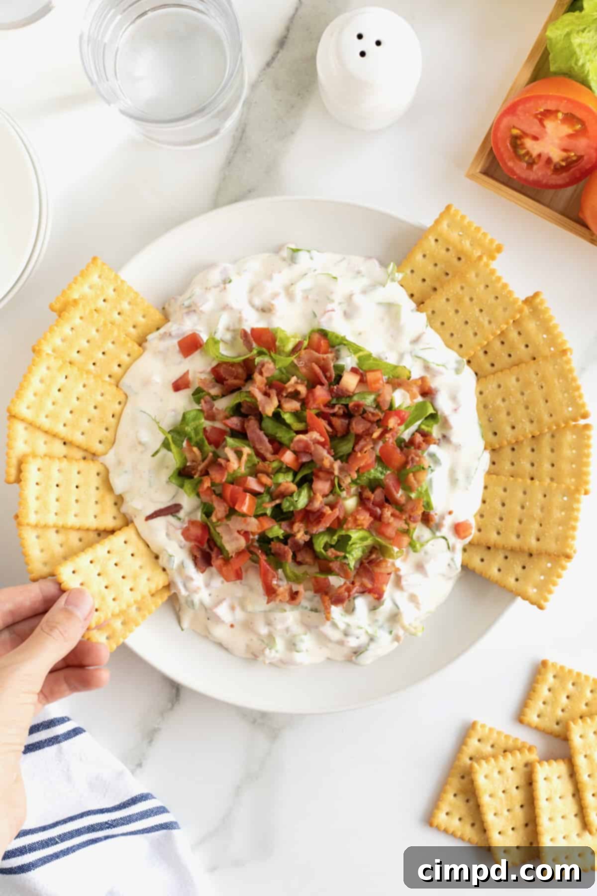 Ultimate BLT Dip 10 A beautifully composed shot of the BLT Dip in a white bowl, garnished and ready, with more club crackers, emphasizing its fresh and inviting presentation for an ideal party spread.