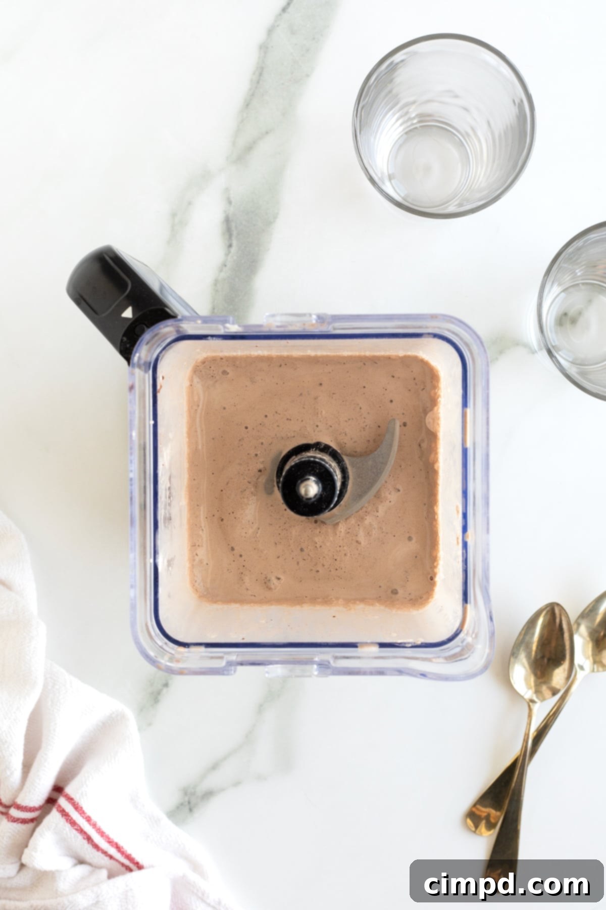 A homemade Wendy's Frosty actively blending in a high-speed blender, creating a vortex of creamy, chocolatey goodness.