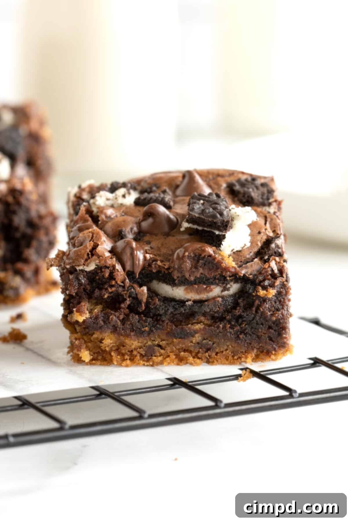 Three-layer brownies on a parchment lined cooling rack, showcasing the distinct layers.