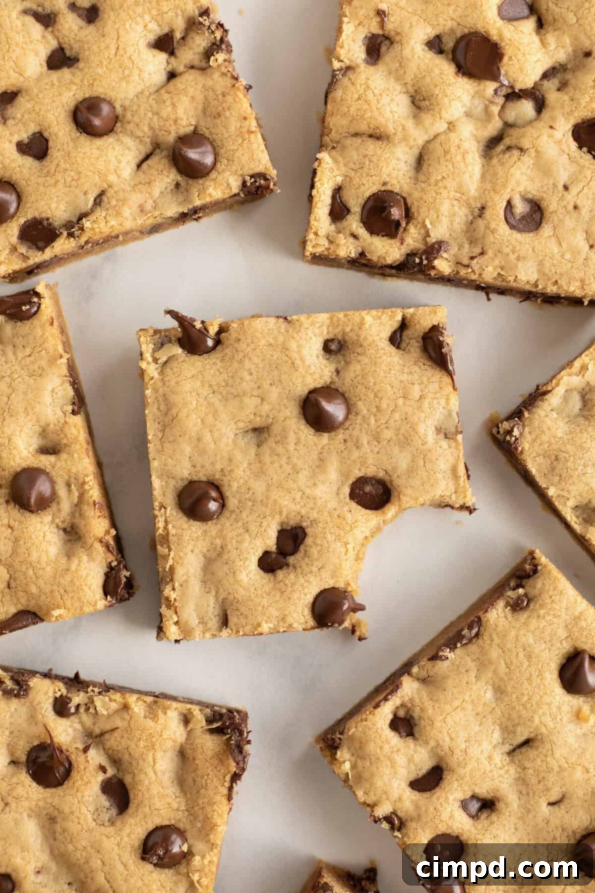 A peanut butter chocolate chip cookie bar with a bite taken out of it.