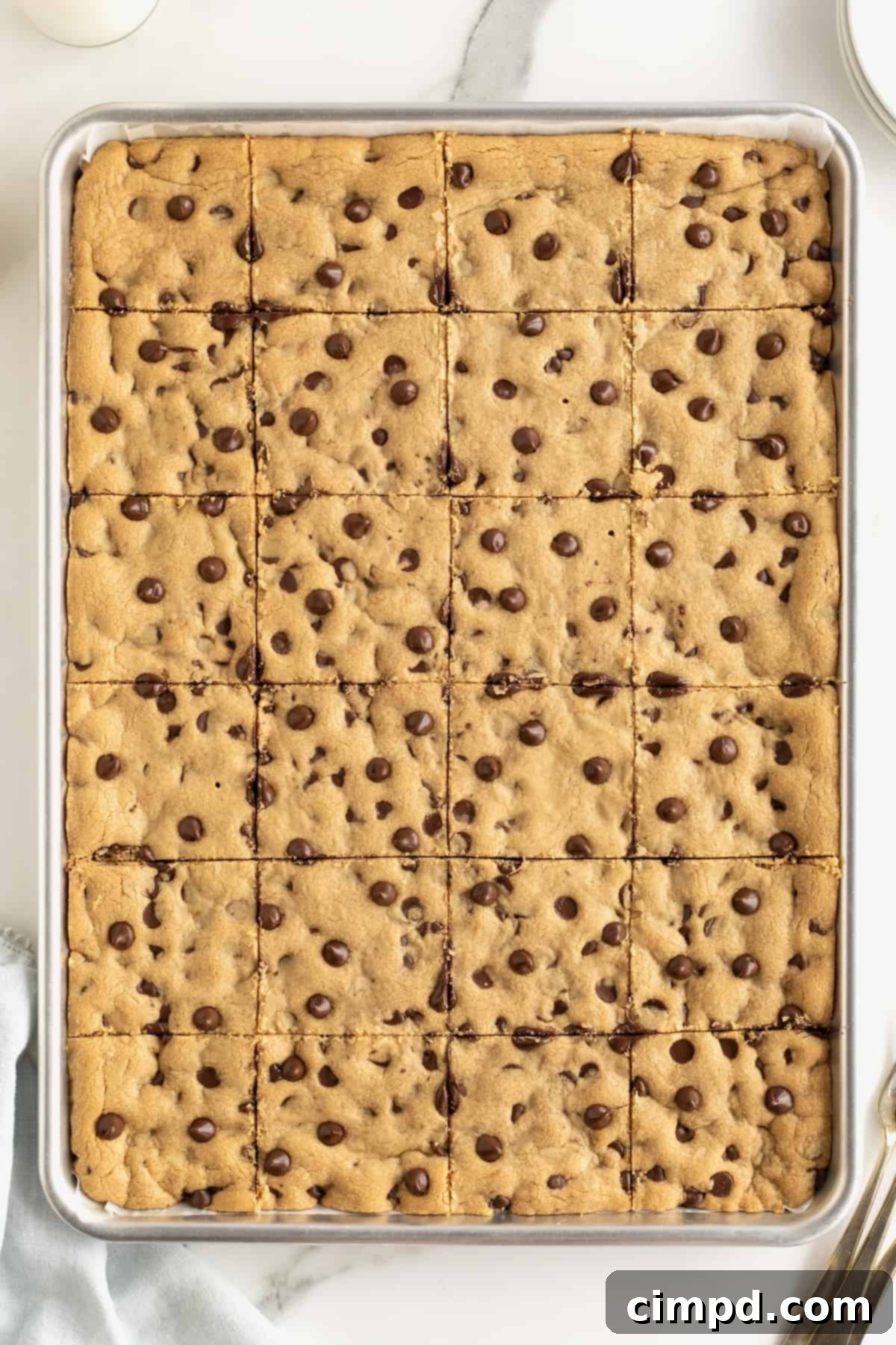 A sheet pan of peanut butter chocolate chip cookies cut into squares.