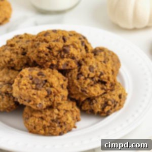 A white round serving platter of mini pumpkin chocolate chip oatmeal cookies.