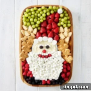 A wood food board decorated with fruit and cookies and marshmallows to look like Santa.