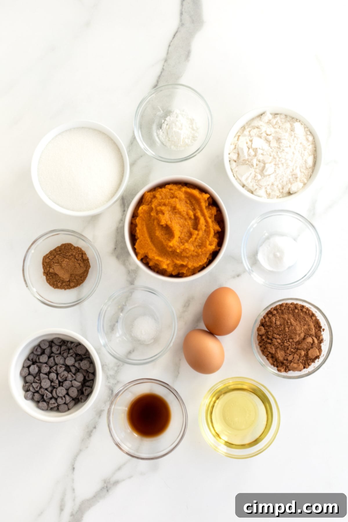 Ingredients for Pumpkin Swirl Brownies in small glass dishes on a white counter. 