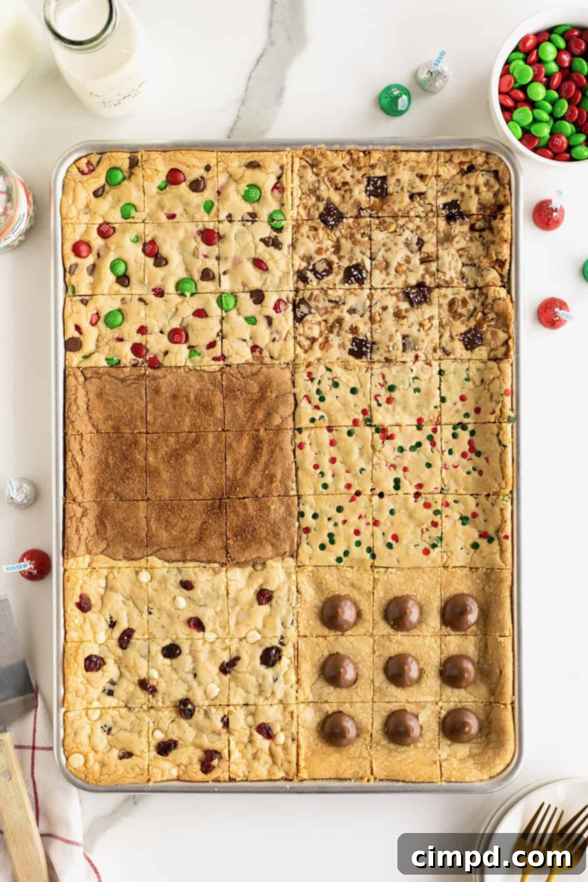 A vibrant selection of six holiday cookie bar flavors arranged neatly on a single sheet pan, set against a pristine white countertop, ready to be enjoyed.
