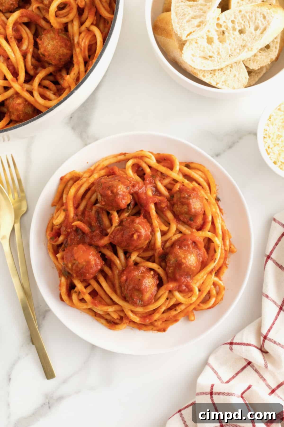 A large white plate with spaghetti and meatballs. 
