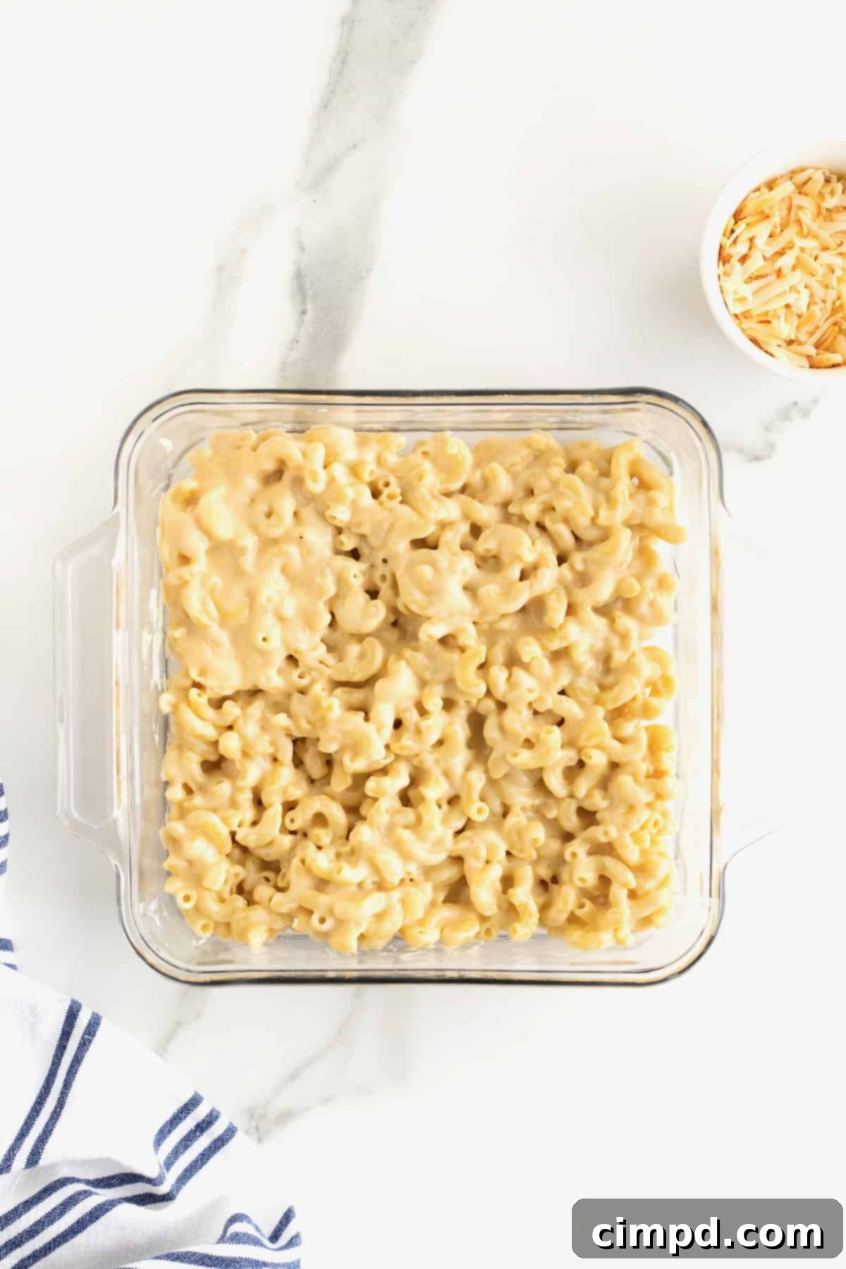 Creamy Muenster Mac and Cheese 8 A square glass dish filled with the macaroni and cheese mixture, ready for baking.