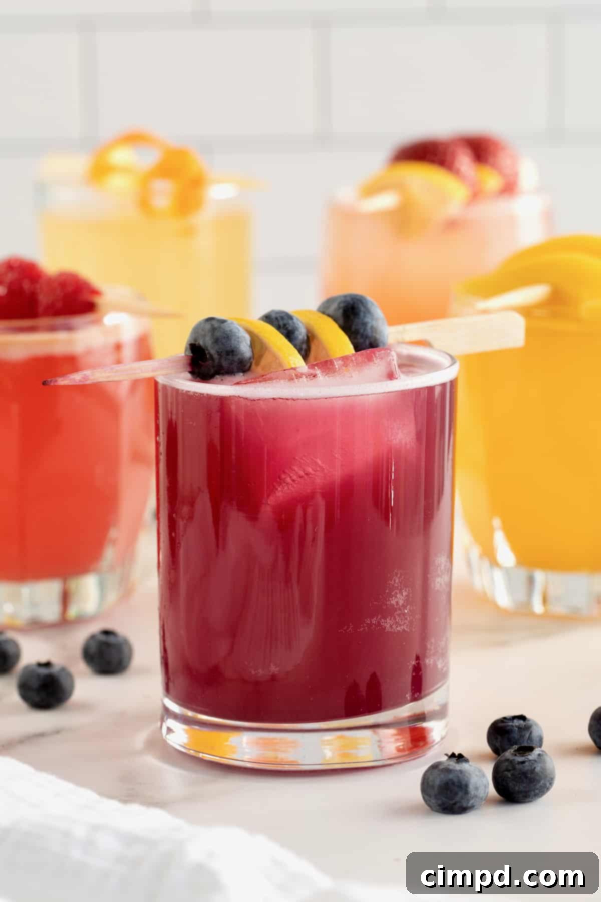 A vibrant selection of jam cocktails including Strawberry Vodka, Orange Tequila, Raspberry Rum, Apricot Bourbon, and Blueberry Gin, garnished with fresh fruit.