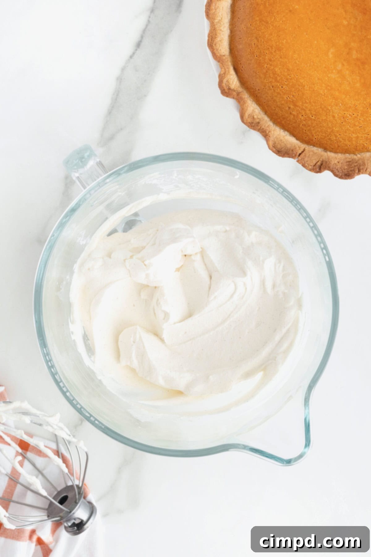 Cream for a pumpkin cream pie in a large glass mixing bowl.