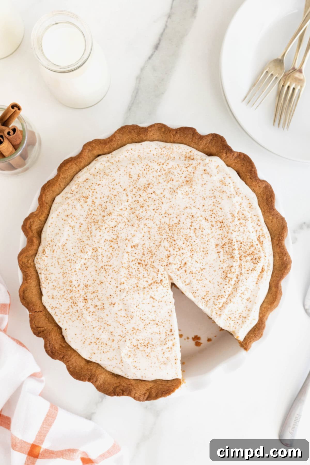 A pumpkin cream pie with a slice out of it.