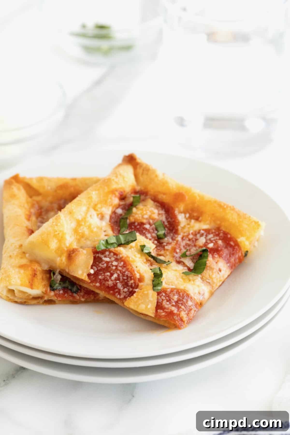 Tortilla Pizza with Stuffed Crust 3 Two slices of stuffed crust tortilla pizza on a stack of three small white plates.