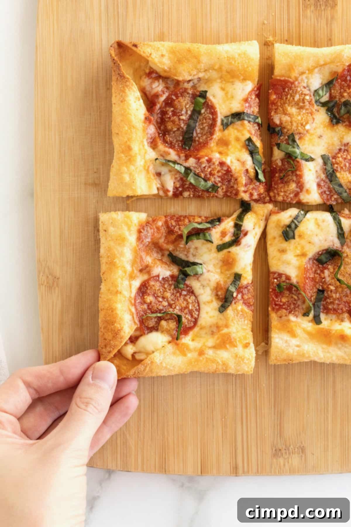 Tortilla Pizza with Stuffed Crust 4 A stuffed crust tortilla pizza on a rectangular light wood cutting board.