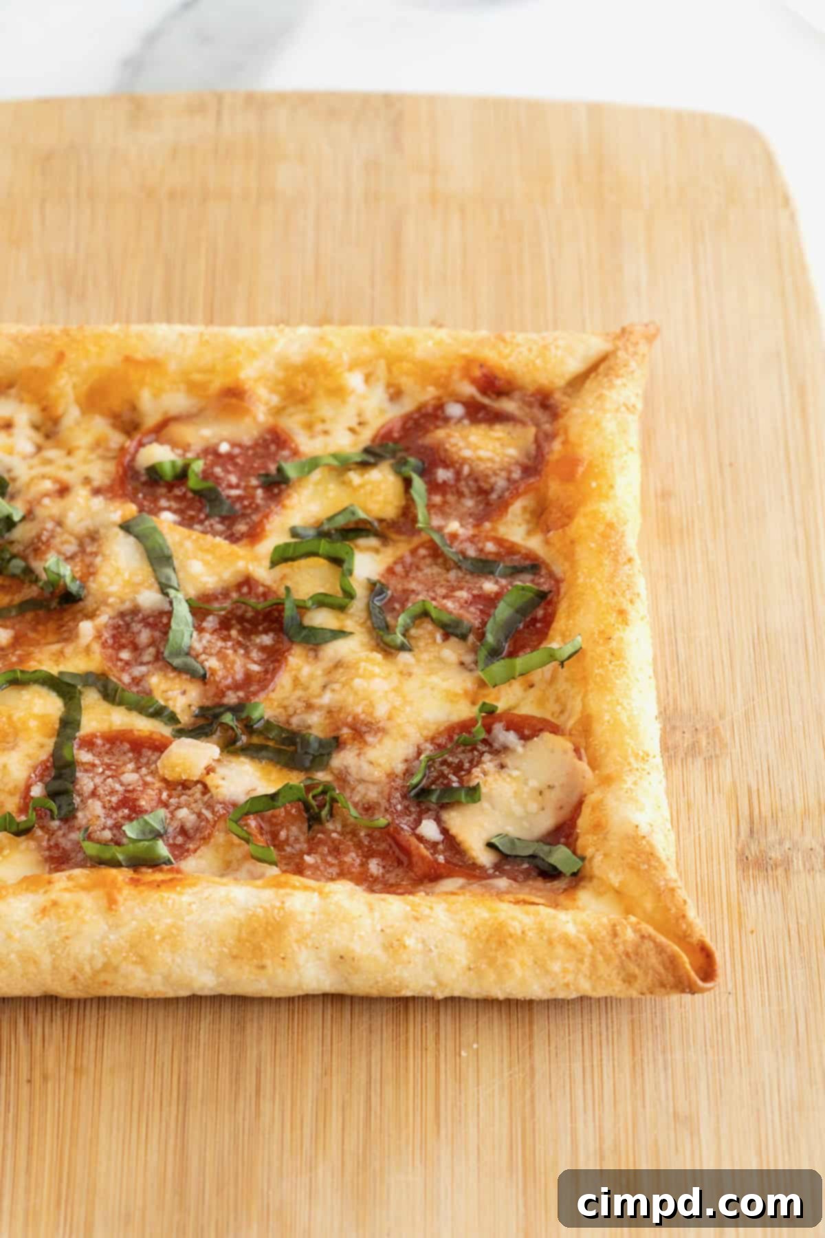 Tortilla Pizza with Stuffed Crust 5 A stuffed crust tortilla pizza on a rectangular light wood cutting board.