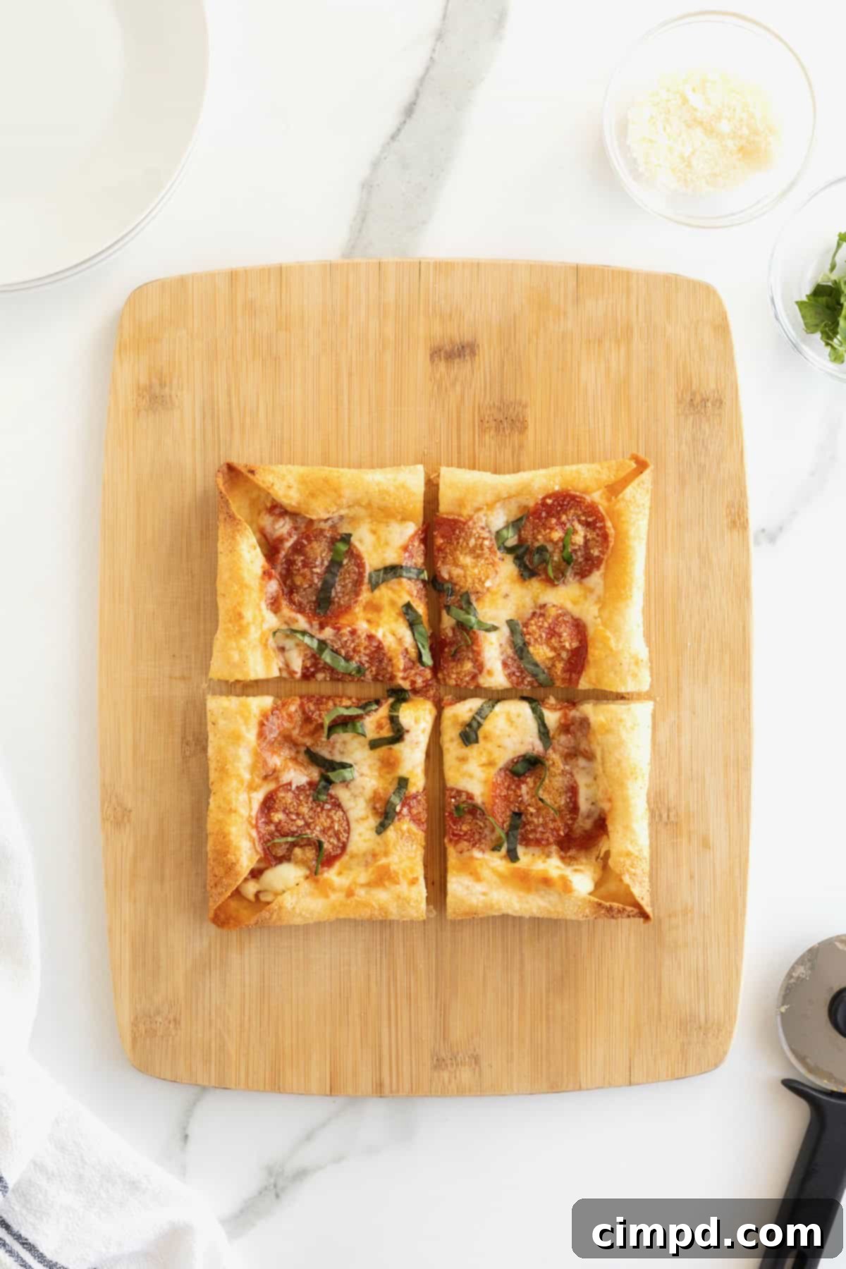 Tortilla Pizza with Stuffed Crust 9 A stuffed crust tortilla pizza cut into four pieces on a rectangular light wood cutting board.
