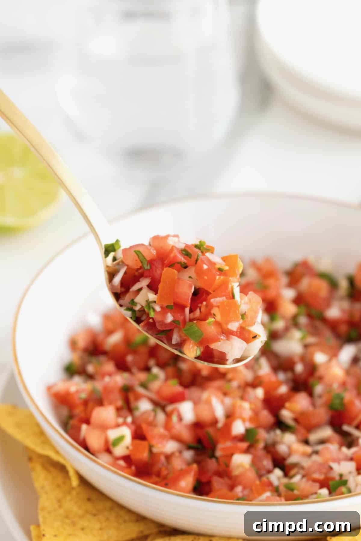 A large white serving bowl of pico de Gallo.