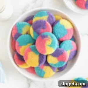 Vibrant Swirl Sugar Cookies 13 A large serving plate stacked with colorful sugar cookies with pink, purple, blue and yellow swirls in them.