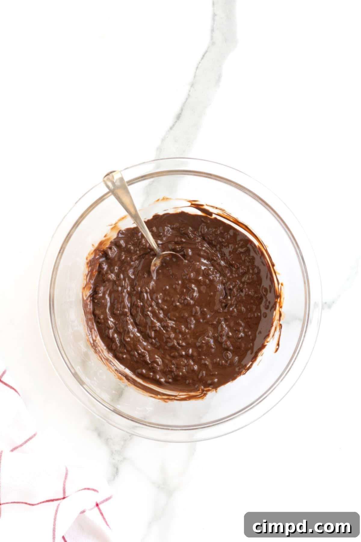 Frozen Chocolate Taco Treats 8 A glass mixing bowl filled with rich melted chocolate, with finely chopped peanuts stirred in for texture and flavor.