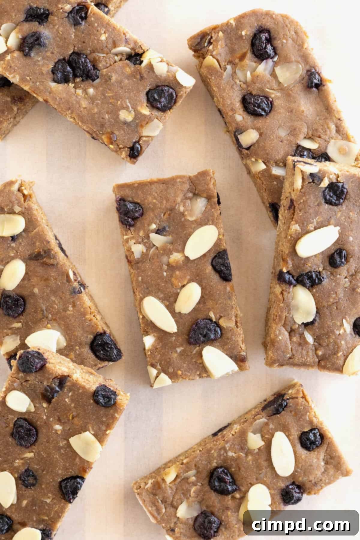 Sunrise Blueberry Banana Almond Bars 3 Six vibrant Blueberry Banana Almond Breakfast Bars arranged beautifully on a piece of parchment paper.