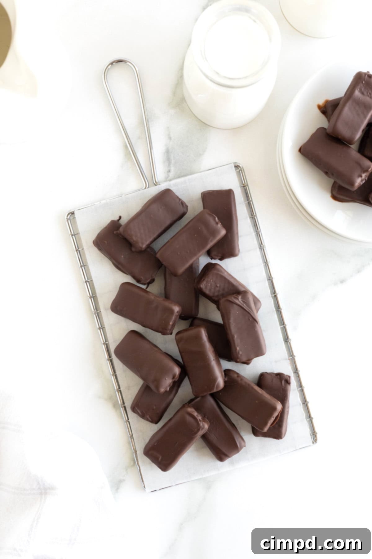 Quick Homemade KitKat Bites 11 A bountiful pile of homemade Kit Kat candy bar bites, expertly crafted and perfectly set, displayed on a parchment-lined cooling rack.