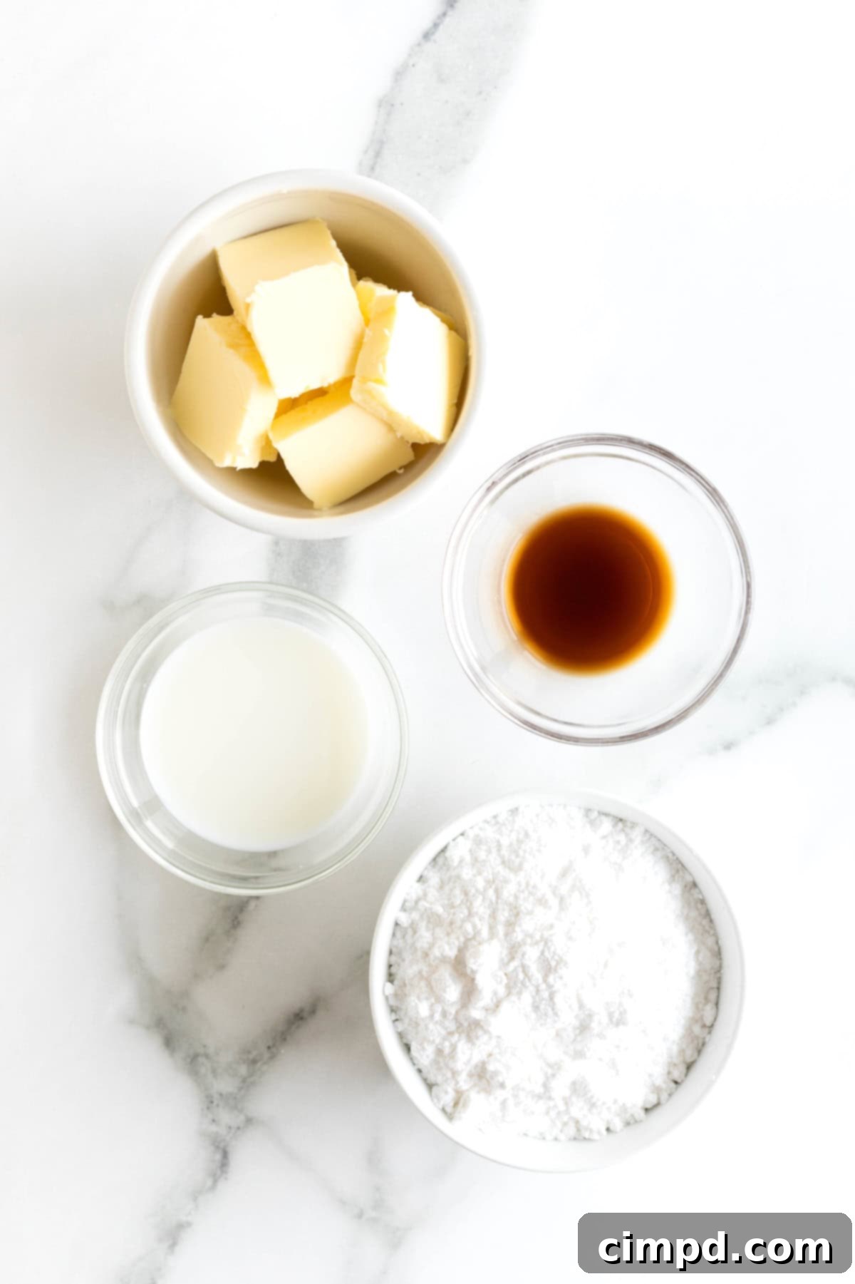 Foolproof Buttercream Frosting 5 Ingredients to make buttercream frosting in small glass dishes on a white marble counter.
