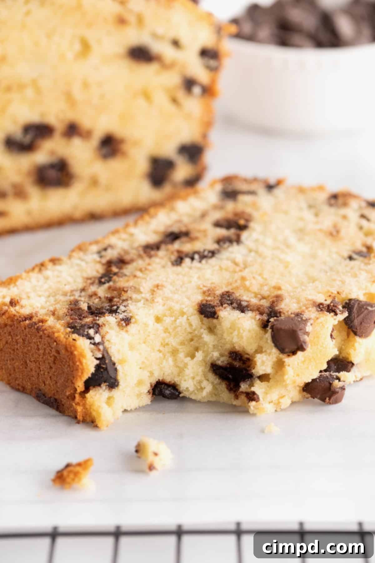 Decadent Chocolate Chip Pound Cake 3 A piece of chocolate chip pound cake with a bite taken out of it on a white marble counter.