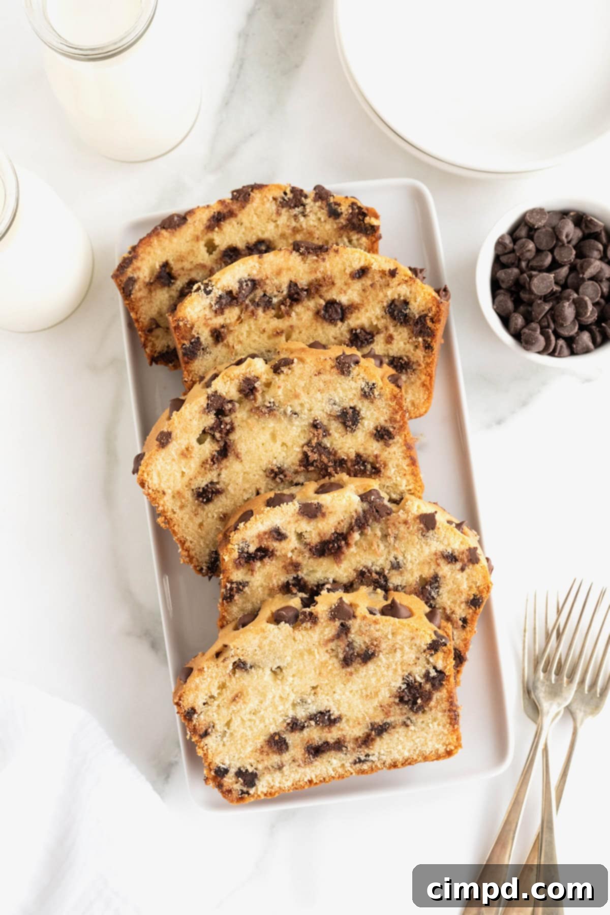 Decadent Chocolate Chip Pound Cake 9 A loaf of chocolate chip pound cake cut in slices on a rectangular white serving dish.