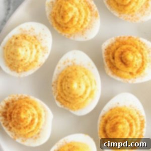 Devilish Delights 10 A large white serving platter of deviled eggs on a white marble counter, ready to be served.