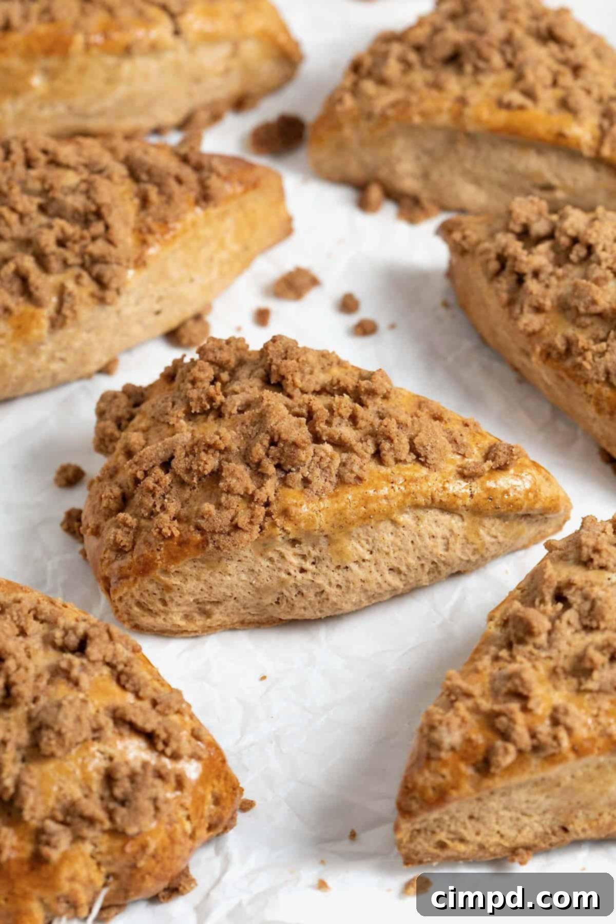 Seven snickerdoodle streusel scones on a white surface, perfectly baked and golden.