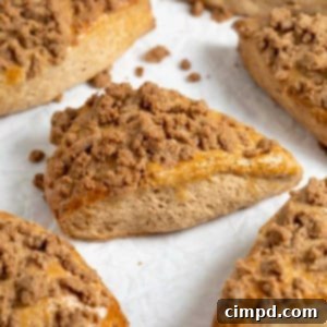 Seven snickerdoodle streusel scones on a white surface.