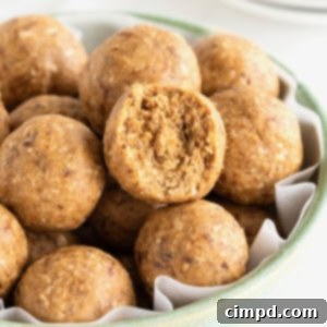 Wholesome Energy Bites 10 Snack bites in a large pale blue earthenware serving bowl on a white marble counter.