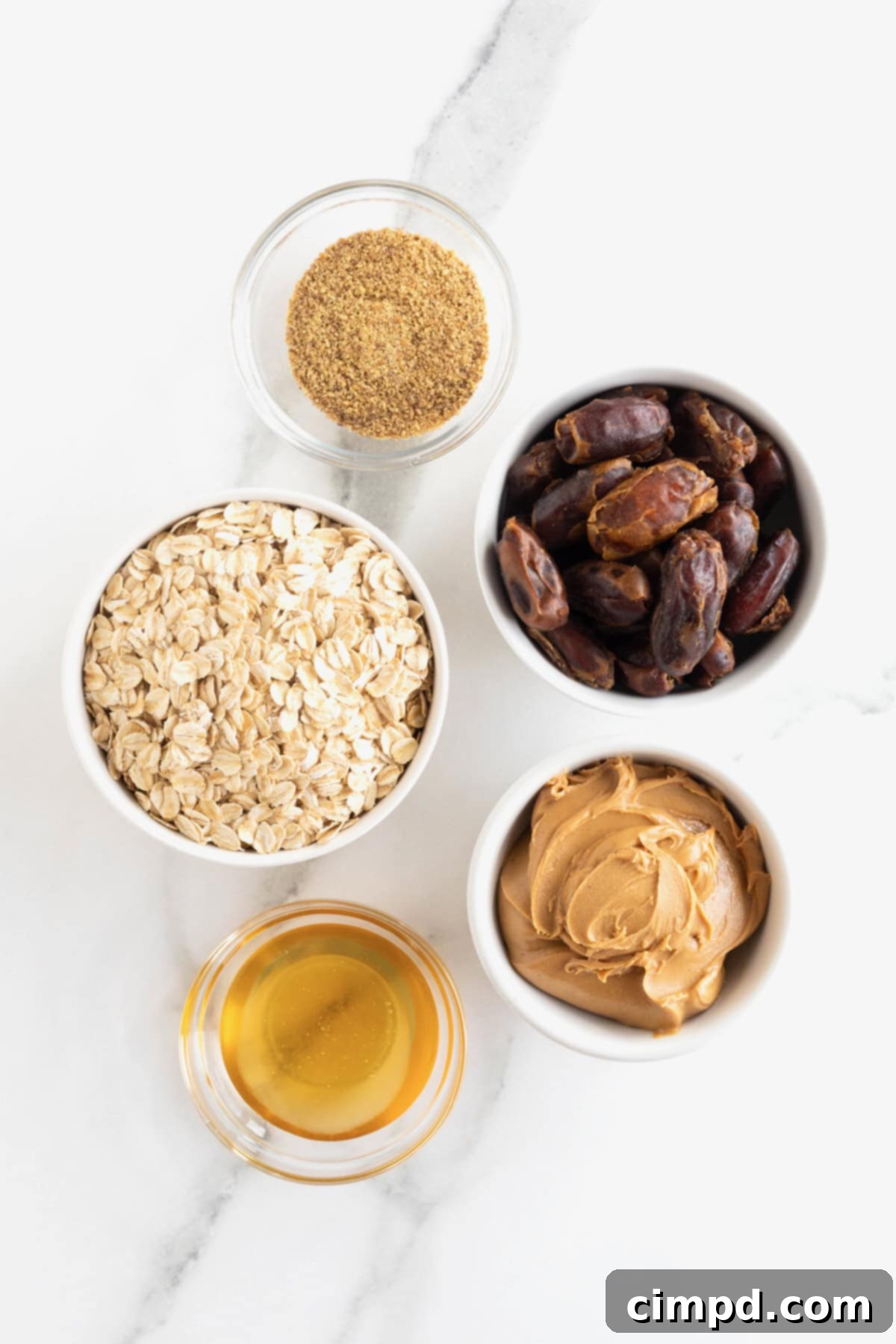 Wholesome Energy Bites 5 Ingredients to make simple energy bites in small white glass dishes on a white marble counter.