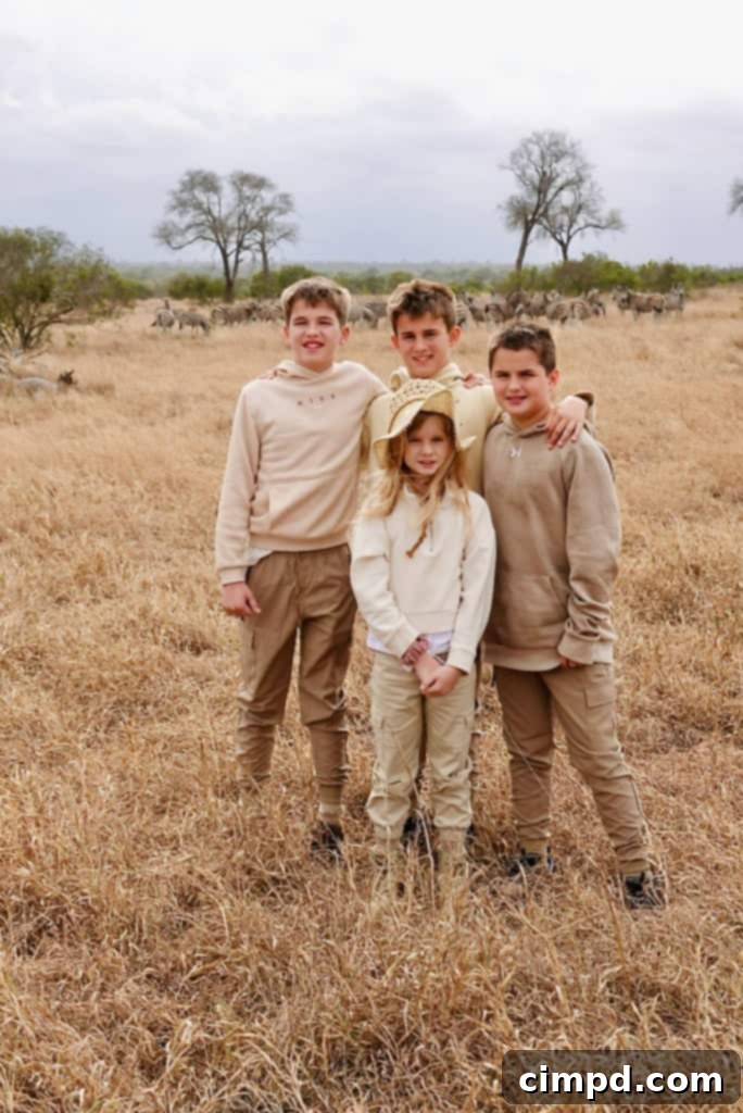 Children wearing muted colors and hats, looking out into the vast African bush.