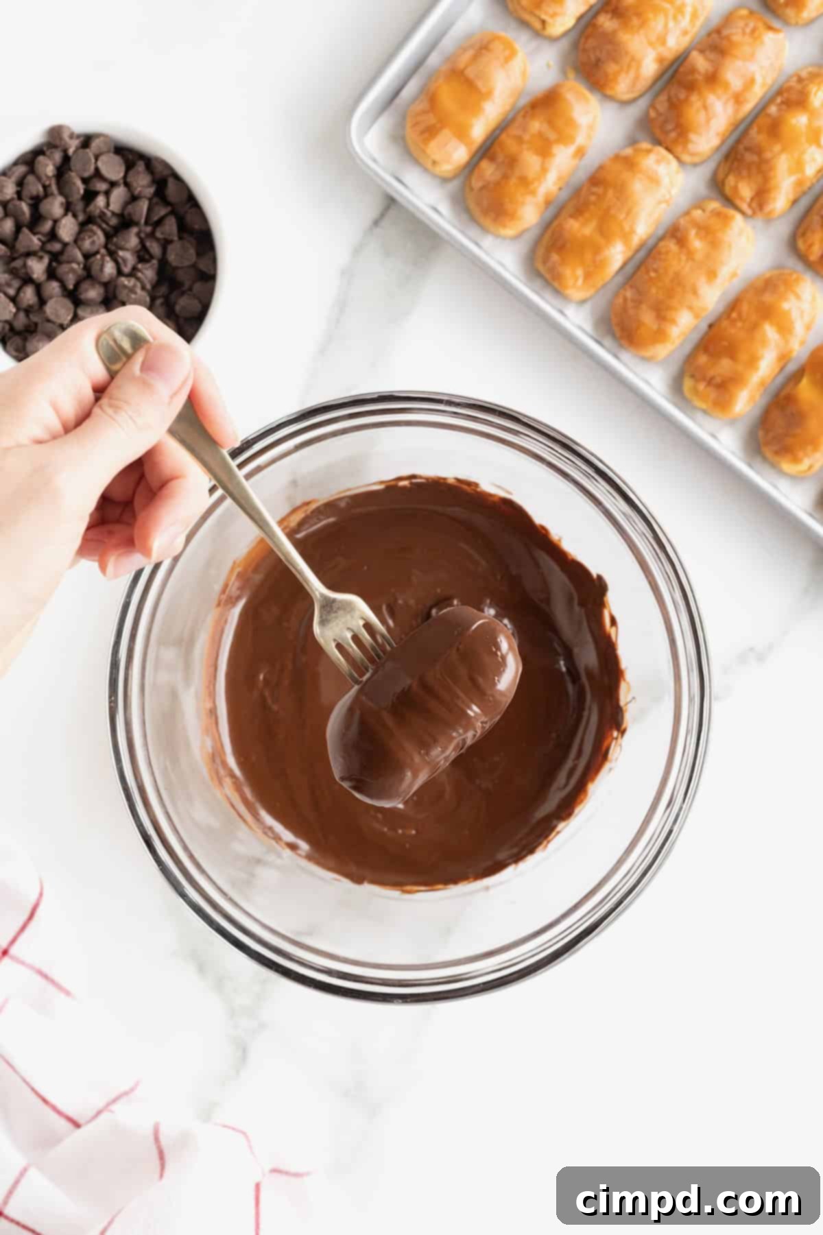 Chewy Homemade Snickers Treats 9 Another homemade Snickers bite on a metal fork, being expertly coated in smooth, melted chocolate, ensuring every surface is perfectly covered.