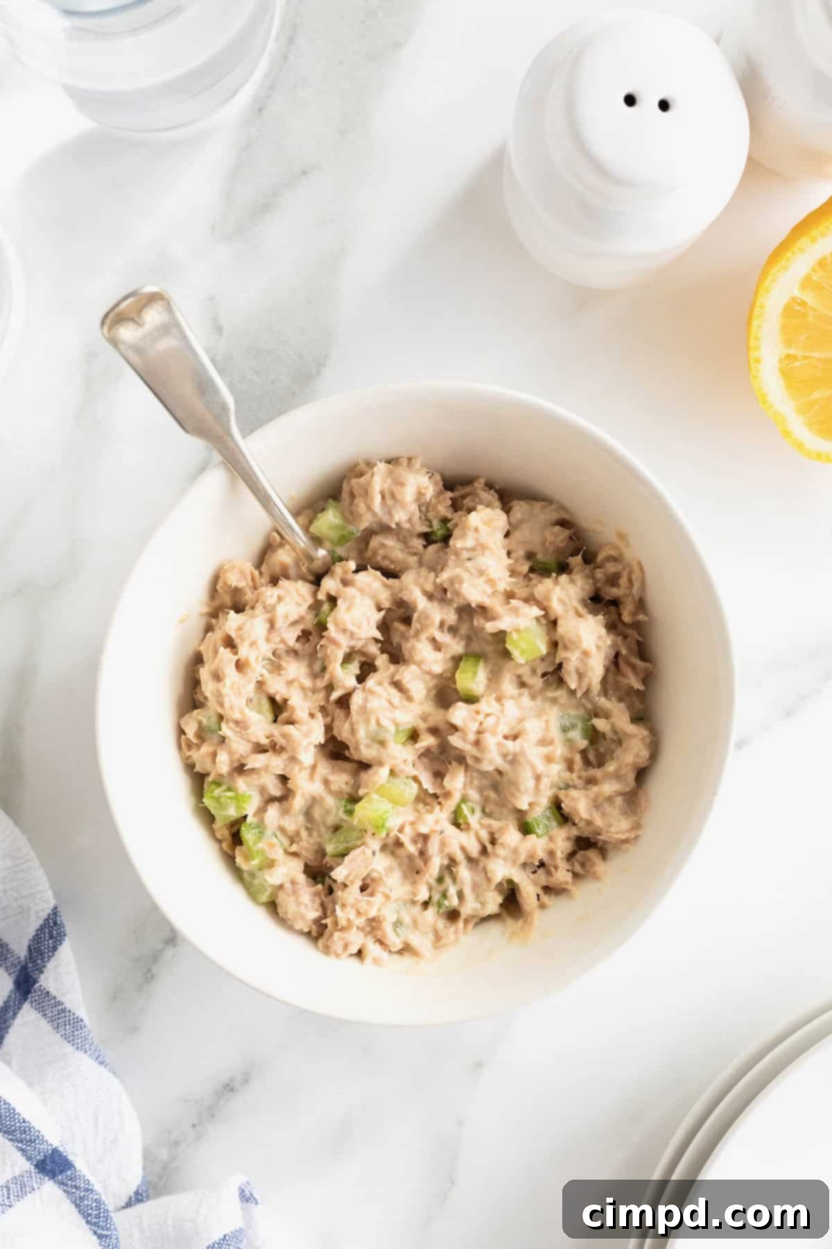 My Tuna Salad 8 A white bowl of tuna salad with a metal spoon sticking out.