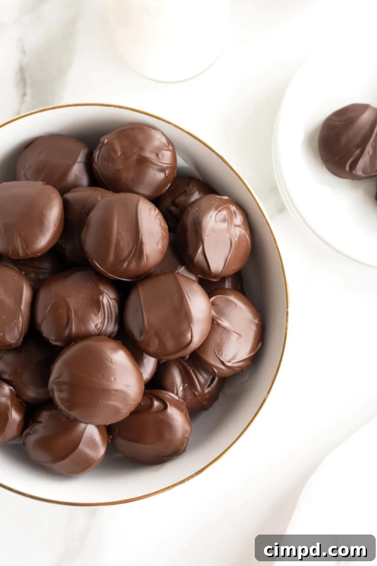A large white bowl of Twix Bites on a white marble counter.