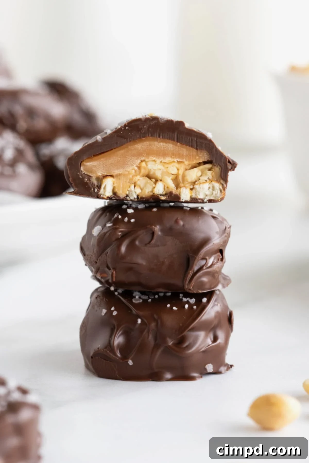 A stack of three Take 5 Bites stacked on a parchment lined baking tray. The top bite is cut in half.